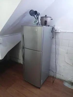 a small refrigerator in a room with a staircase at Departamento 1dormitorio 3A in Lima