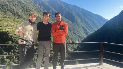 three men standing in front of a mountain at TUMI Specialty Travel in Colcapampa
