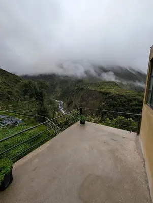 a room with a view of a mountain with clouds at TUMI Specialty Travel in Colcapampa