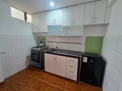 a kitchen with white cabinets and a black stove at 402G Modern equipped apartment in Abancay