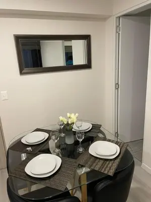 a dining room table with plates and glasses and a mirror at Departamento con baño y cocina equipada in Lima