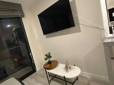 a living room with a tv on the wall at Departamento con baño y cocina equipada in Lima