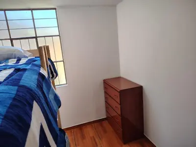 a bedroom with a bed and a dresser and a window at Family Days in Ica