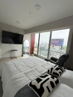 a bedroom with a large bed and a large window at Acogedor Loft con ubicación céntrica en Lima in San Antonio
