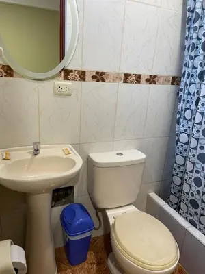 a bathroom with a toilet and a sink and a mirror at Misky Illari Hospedaje in Ica