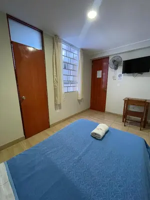 a bedroom with a blue bed and a window at Misky Illari Hospedaje in Ica