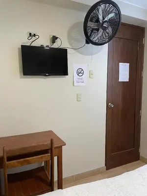 a room with a fan and a table and a door at Misky Illari Hospedaje in Ica