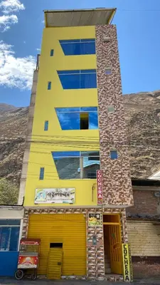 a yellow building with a yellow door at Churin Hostal J&D in Churín