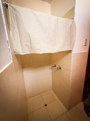 a shower with a white sheet on top of it at Hospedaje Arco Real in Ica