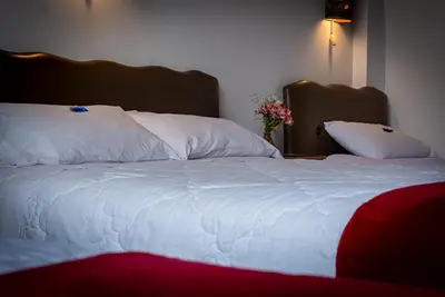 a large bed with white sheets and pillows on it at Casona Santa Catalina Cusco in Cusco