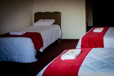 a room with two beds with red and white blankets at Casona Santa Catalina Cusco in Cusco