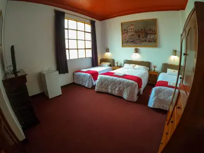 a bedroom with two beds and a television in it at Casona Santa Catalina Cusco in Cusco