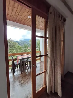 a room with a sliding glass door with a table and bench at BellaVista 2 habitaciones con balcón in Oxapampa
