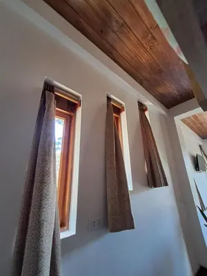 a room with two windows with curtains on them at BellaVista 2 habitaciones con balcón in Oxapampa
