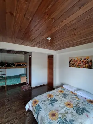 a bedroom with a bed and a wooden ceiling at BellaVista 2 habitaciones con balcón in Oxapampa