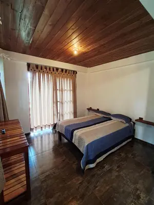 a bedroom with two beds and a wooden ceiling at BellaVista 2 habitaciones con balcón in Oxapampa