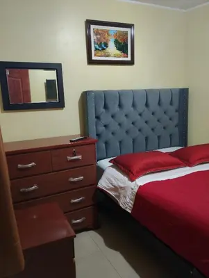 a bedroom with a bed and a dresser and a mirror at Hotel D'Gloria Churin in Churín