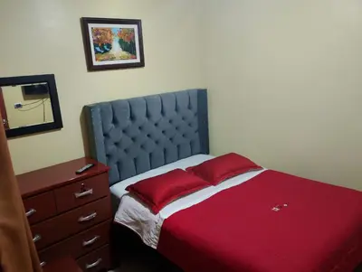 a bedroom with a bed with red sheets and a dresser at Hotel D'Gloria Churin in Churín