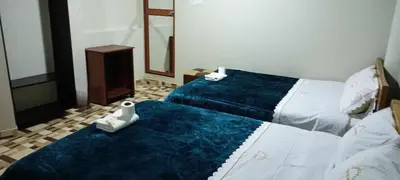 a hotel room with two beds and a mirror at Hostal Casa Blanca in Ayacucho