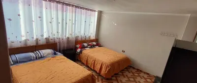 a bedroom with two beds and a window at Hostal Casa Blanca in Ayacucho