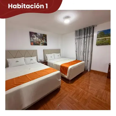 two beds in a hotel room with at Departamentos Sumaq Plaza - Bellido in Ayacucho
