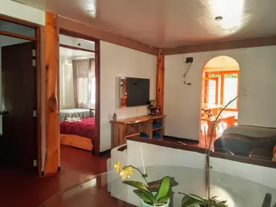 a living room with a tub and a bedroom at La casa de Cuni in Oxapampa