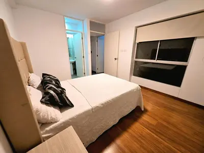a bedroom with a bed and a large window at barranco apartament R&M in Lima