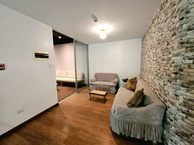 a living room with a couch and a brick wall at barranco apartament R&M in Lima