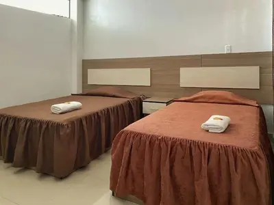 two beds in a room with towels on them at Hotel Marabi in Quillabamba