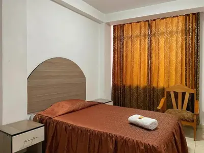 a bedroom with a bed with two towels on it at Hotel Marabi in Quillabamba
