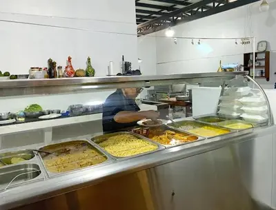 a chef preparing food in a restaurant kitchen at Hotel Marabi in Quillabamba