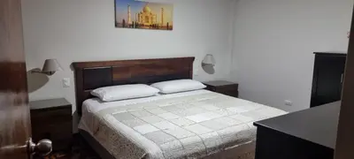 a bedroom with a bed and a picture on the wall at Duplex en San Borja in Lima