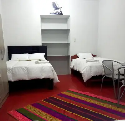 a bedroom with two beds and a colorful rug at Apartamento Privado en San Pedro Cusco in Cusco