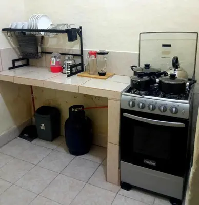 a kitchen with a stove with pots and pans on it at Apartamento Privado en San Pedro Cusco in Cusco