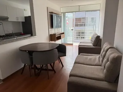 a living room with a couch and a table at Departamento San Sebastian in Lima