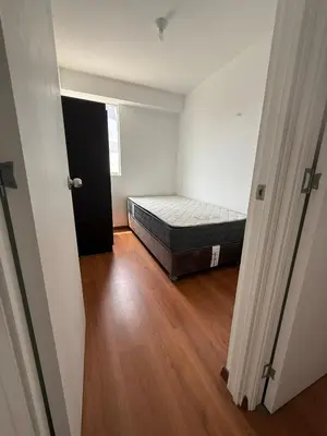 an empty room with a bed and a wooden floor at Departamento San Sebastian in Lima