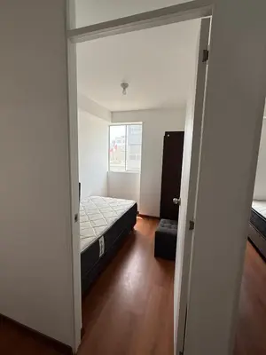 a small bedroom with a bed and a window at Departamento San Sebastian in Lima