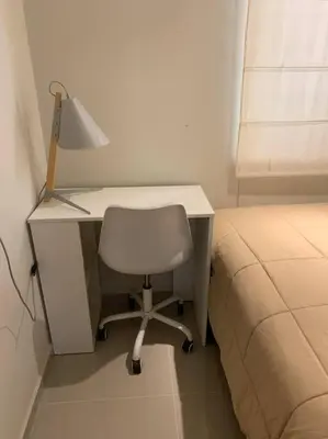 a desk with a lamp and a chair next to a bed at CASA DUNE Acogedora casa a 7 minutos Huacachina in Ica