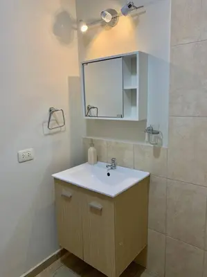 a bathroom with a sink and a mirror at CASA DUNE Acogedora casa a 7 minutos Huacachina in Ica