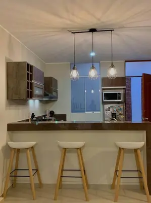 a kitchen with two stools at a kitchen counter at CASA DUNE Acogedora casa a 7 minutos Huacachina in Ica