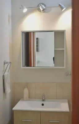 a bathroom with a white sink and a mirror at CASA DUNE Acogedora casa a 7 minutos Huacachina in Ica