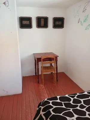 a room with a wooden table and a chair at Gatanas House in Cusco