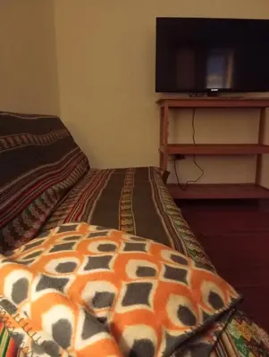 a bedroom with a bed and a flat screen tv at Gatanas House in Cusco