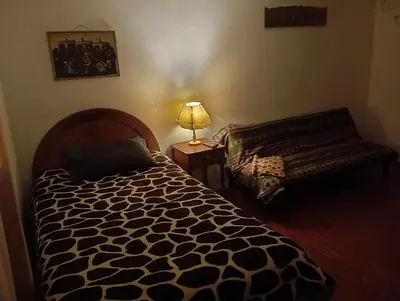 a bedroom with a bed and a lamp on a table at Gatanas House in Cusco