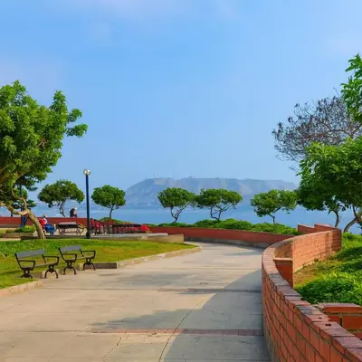 a walkway in a park with benches and the water at Bella vista al malecón Lima - Miraflores in Lima