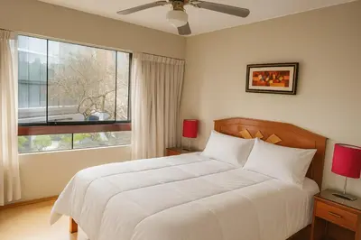 a bedroom with a bed and a large window at Bella vista al malecón Lima - Miraflores in Lima