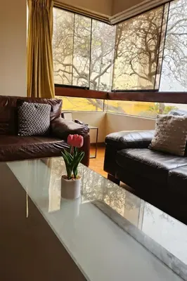 a living room with a glass table and a couch at Bella vista al malecón Lima - Miraflores in Lima