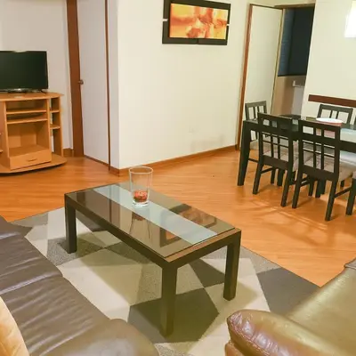 a living room with a glass coffee table and chairs at Bella vista al malecón Lima - Miraflores in Lima