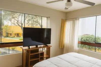 a bedroom with a bed and a flat screen tv at Bella vista al malecón Lima - Miraflores in Lima
