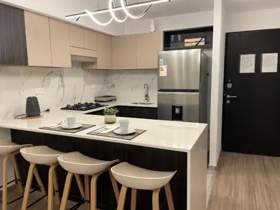 a kitchen with a counter with stools and a refrigerator at Brand new apartment in Miraflores in Lima
